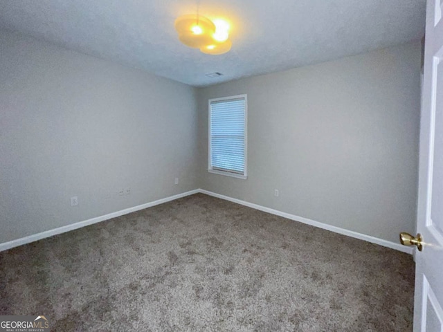 unfurnished room with dark colored carpet