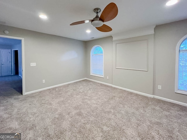 carpeted spare room with a healthy amount of sunlight and ceiling fan