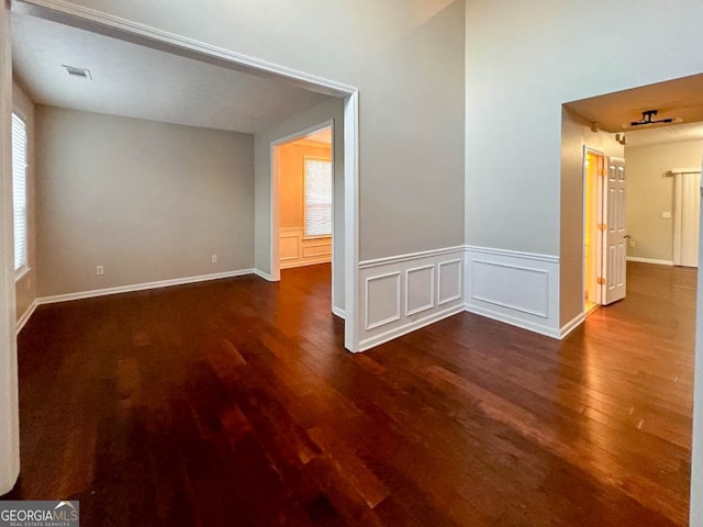 empty room with dark hardwood / wood-style flooring