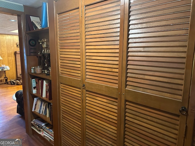 details featuring hardwood / wood-style floors, a textured ceiling, and wood walls