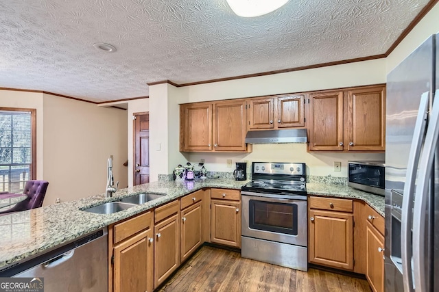 2582 Fairview Ln, Jonesboro, GA 30236 - kitchen with light stone countertops, under cabinet range hood, appliances with stainless steel finishes, dark wood-style floors, and a sink