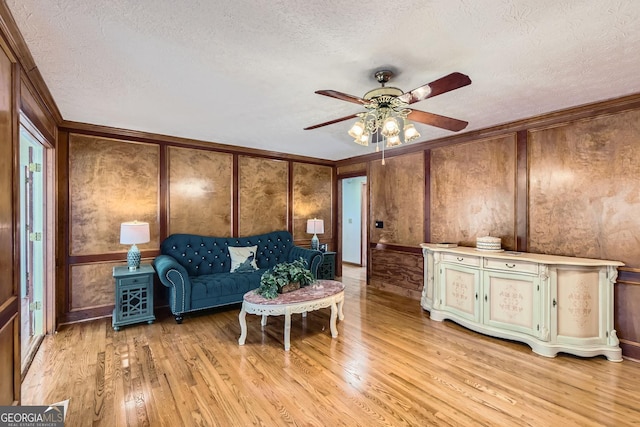 2582 Fairview Ln, Jonesboro, GA 30236 - living room with a decorative wall, light wood-style floors, ceiling fan, and a textured ceiling