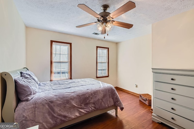 2582 Fairview Ln, Jonesboro, GA 30236 - bedroom with visible vents, a ceiling fan, a textured ceiling, wood finished floors, and baseboards