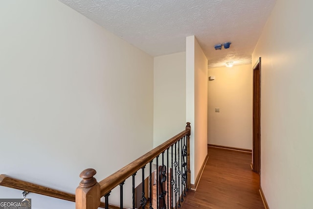 2582 Fairview Ln, Jonesboro, GA 30236 - hallway featuring an upstairs landing, wood finished floors, baseboards, and a textured ceiling