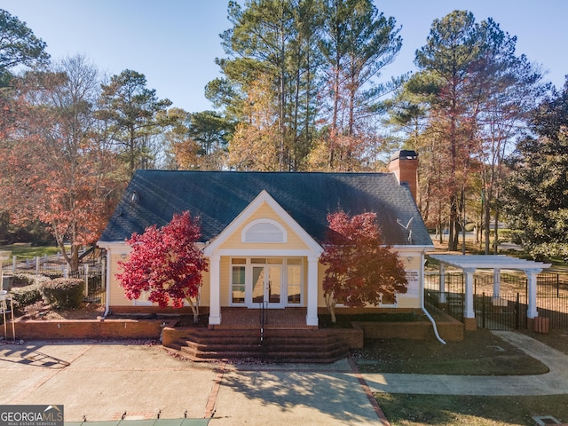 2582 Fairview Ln, Jonesboro, GA 30236 - view of front facade with roof with shingles, a detached carport, a chimney, and fence