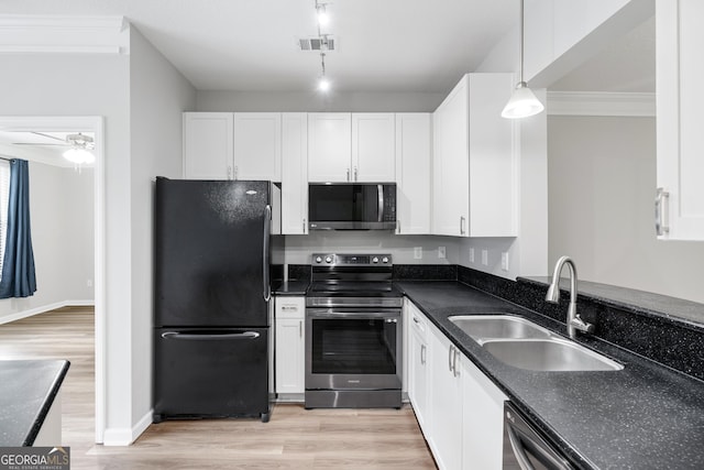 kitchen with appliances with stainless steel finishes, light wood-type flooring, sink, pendant lighting, and white cabinetry