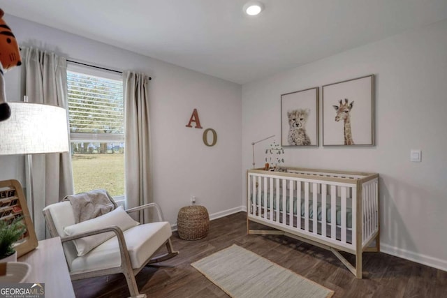 bedroom featuring dark hardwood / wood-style flooring and a crib