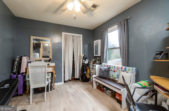 sitting room featuring a textured ceiling, light hardwood / wood-style floors, and ceiling fan