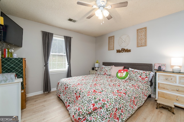 bedroom featuring ceiling fan, a textured ceiling, and light hardwood / wood-style flooring