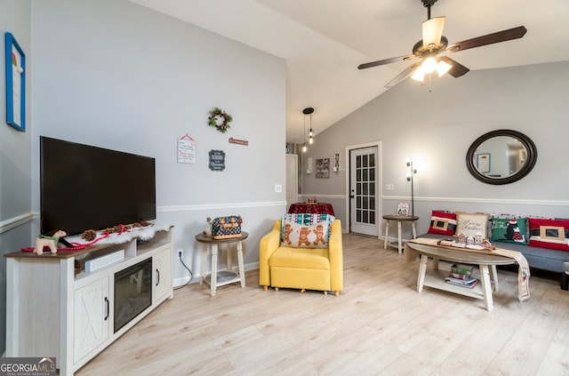 living room featuring ceiling fan, light wood-type flooring, and lofted ceiling