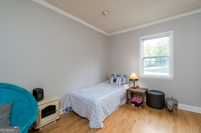 bedroom with wood-type flooring, ornamental molding, and a textured ceiling