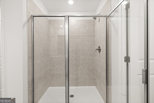 bathroom featuring a shower with shower door