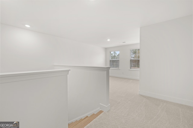 hallway with light colored carpet