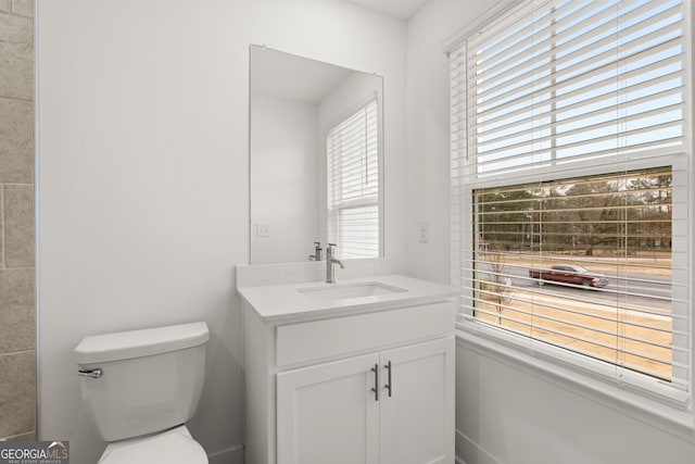 bathroom featuring plenty of natural light, vanity, and toilet