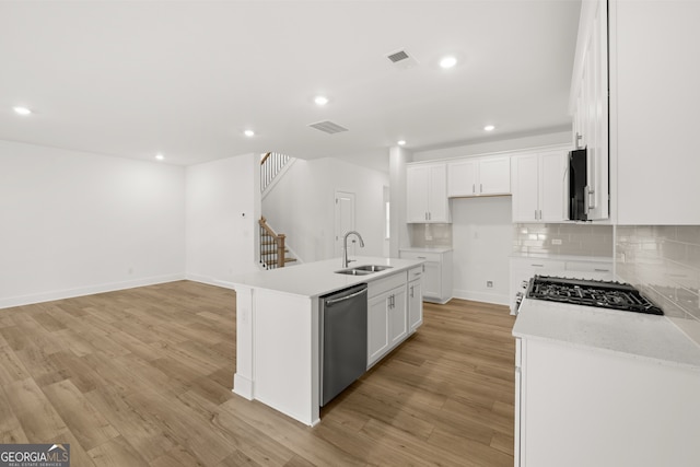 kitchen featuring sink, white cabinetry, an island with sink, and stainless steel appliances