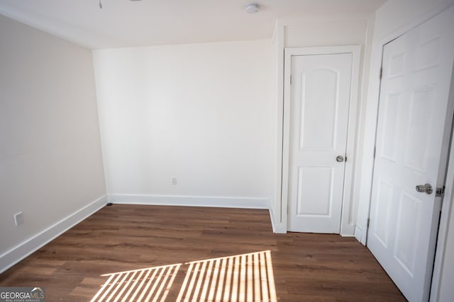 unfurnished room with dark hardwood / wood-style flooring