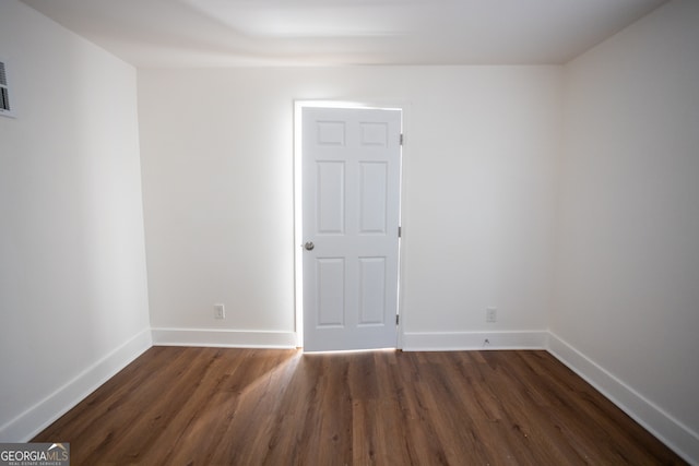 unfurnished room with dark hardwood / wood-style flooring