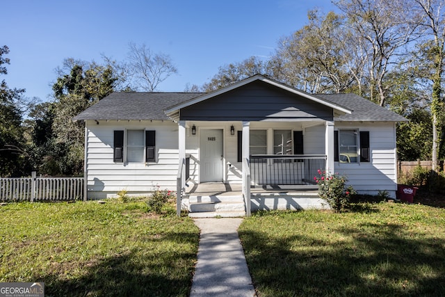 bungalow featuring covered porch and a front lawn