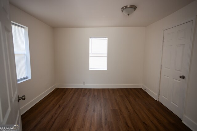 unfurnished room with a wealth of natural light and dark wood-type flooring