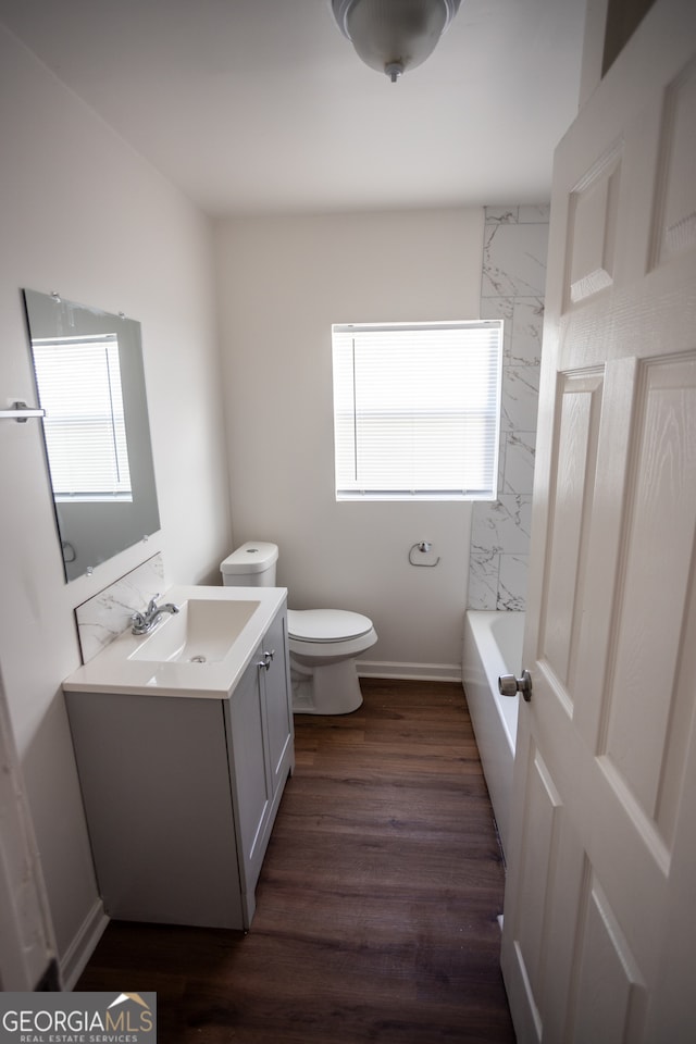 bathroom with plenty of natural light, vanity, hardwood / wood-style floors, and toilet