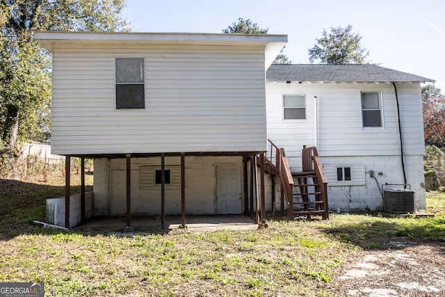 rear view of house with a lawn and central AC