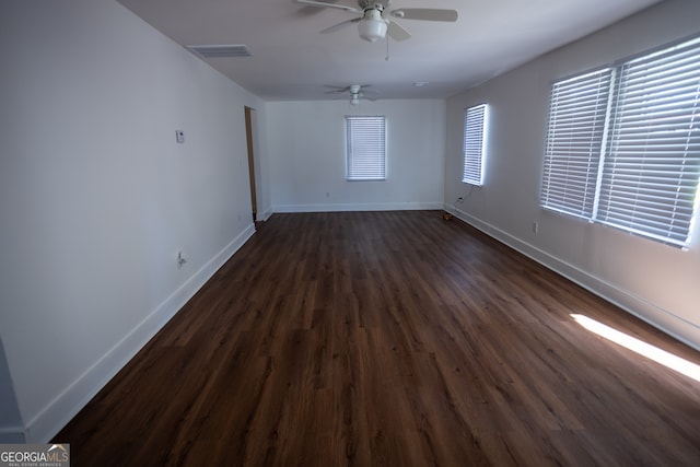 unfurnished room with ceiling fan and dark wood-type flooring