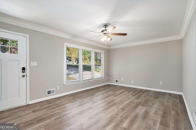 spare room featuring crown molding, a healthy amount of sunlight, and hardwood / wood-style flooring