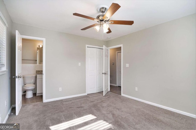 unfurnished bedroom featuring carpet, ensuite bathroom, and ceiling fan