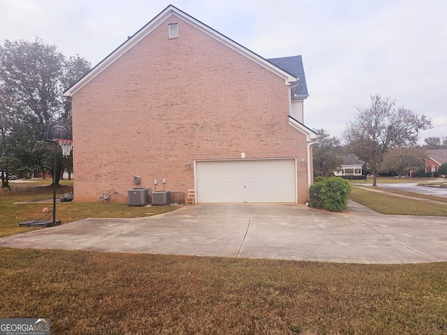 view of home's exterior with a yard, central AC unit, and a garage