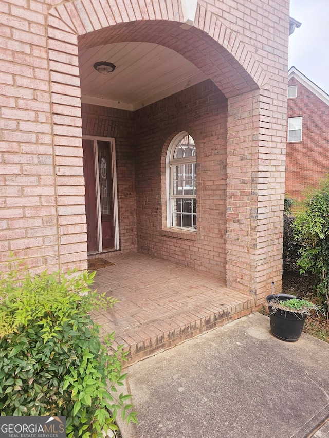 view of exterior entry with a patio