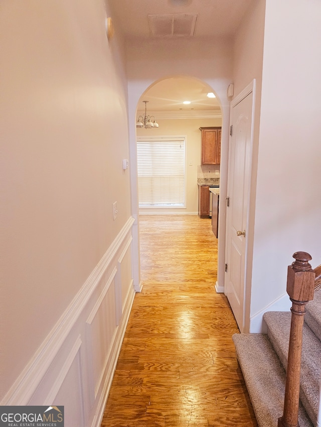 hall with crown molding and light wood-type flooring