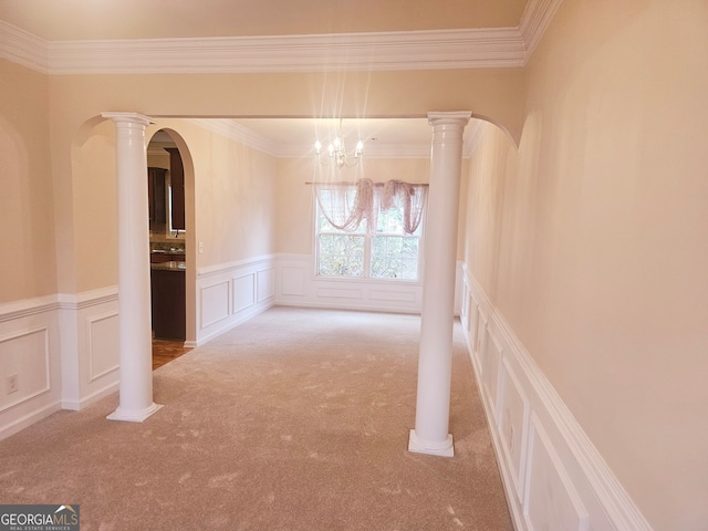 unfurnished room with a notable chandelier, carpet, and crown molding