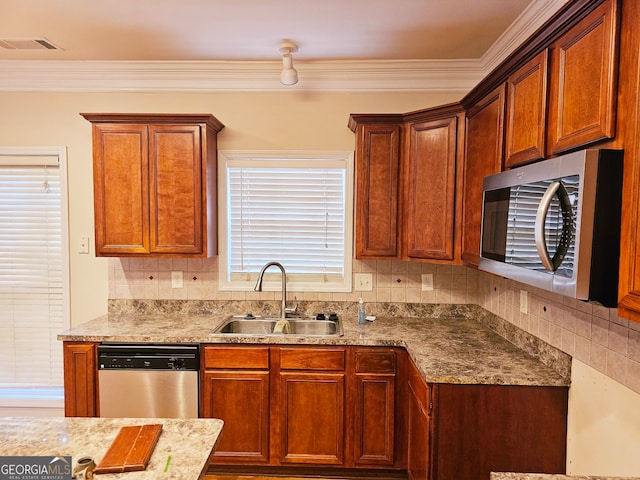 kitchen with backsplash, a healthy amount of sunlight, appliances with stainless steel finishes, and sink