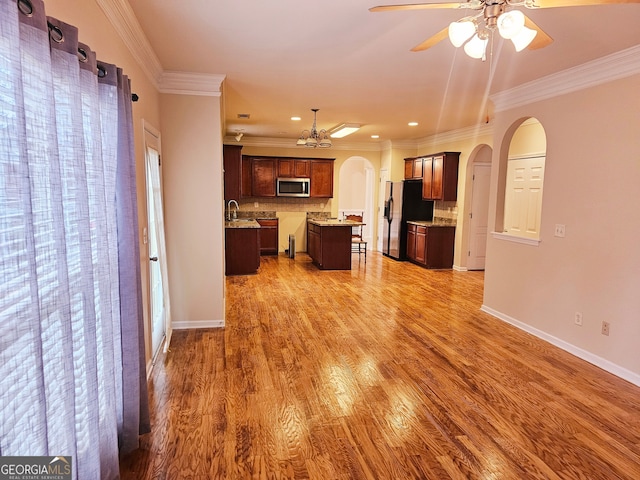 unfurnished living room with crown molding, hardwood / wood-style floors, and a wealth of natural light