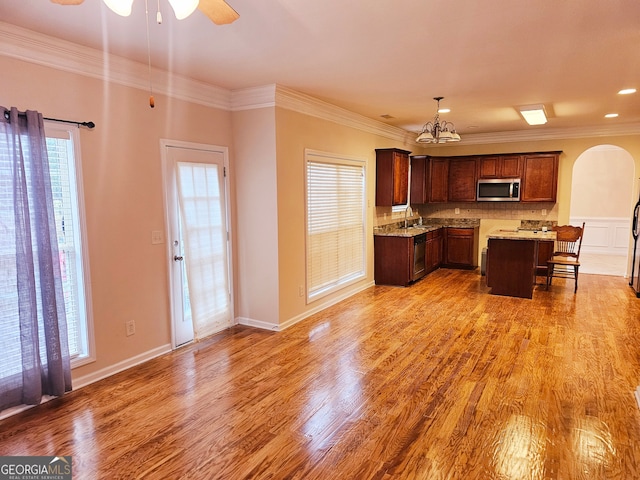 kitchen with appliances with stainless steel finishes, crown molding, and a wealth of natural light