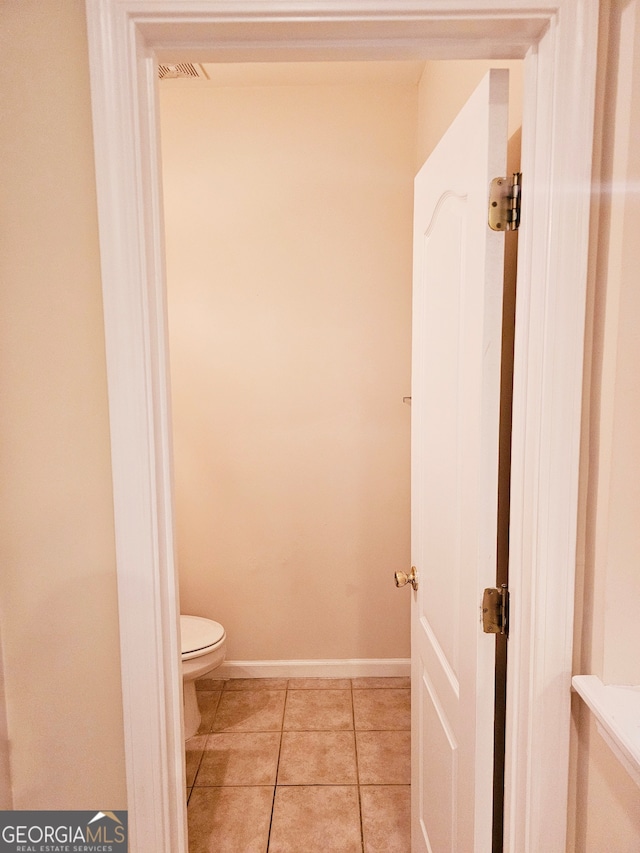 bathroom with toilet and tile patterned flooring