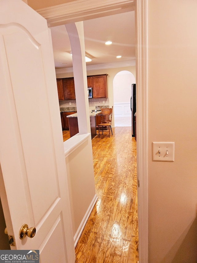 corridor featuring light hardwood / wood-style flooring and ornamental molding