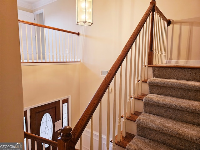 staircase with crown molding and wood-type flooring