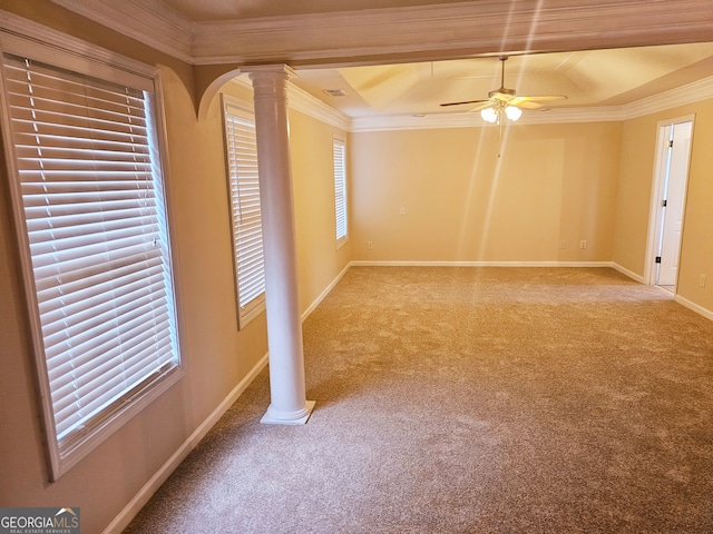 unfurnished room featuring crown molding, light colored carpet, plenty of natural light, and decorative columns