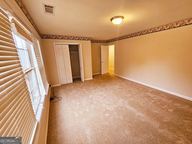 unfurnished bedroom featuring a closet and carpet flooring