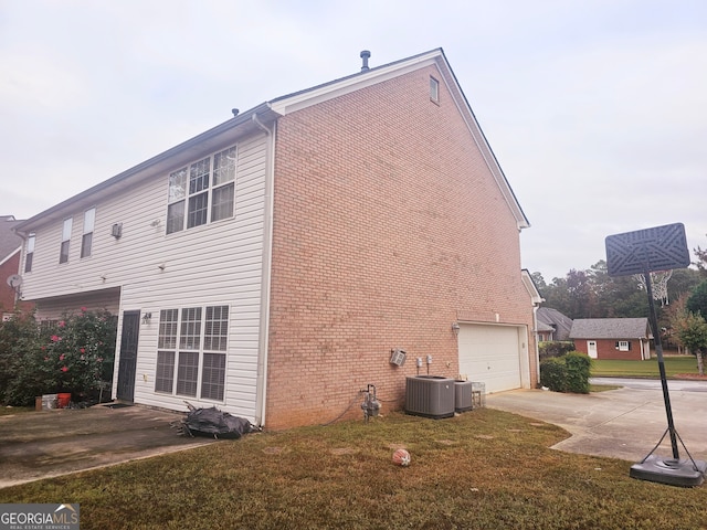 view of property exterior with central AC, a lawn, and a garage