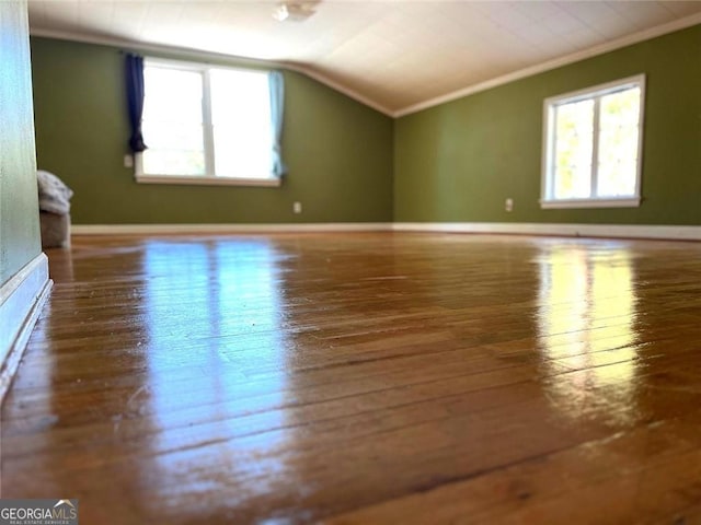 additional living space with hardwood / wood-style flooring and vaulted ceiling