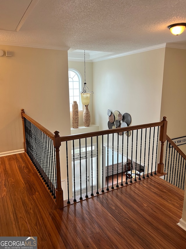 stairway featuring ornamental molding, a textured ceiling, a chandelier, and hardwood / wood-style floors