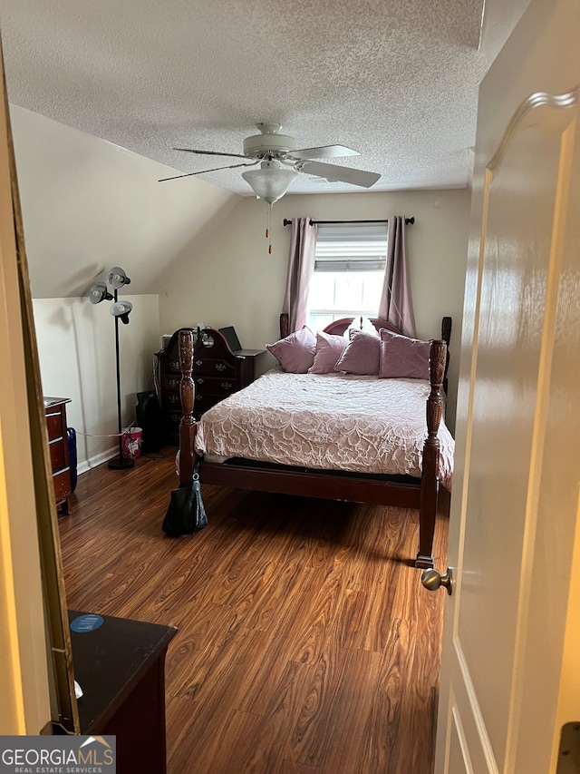 bedroom featuring a textured ceiling, wood-type flooring, vaulted ceiling, and ceiling fan