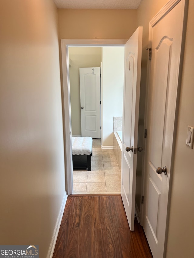 hall with wood-type flooring and a textured ceiling