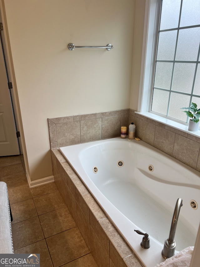 bathroom with tile patterned floors and tiled bath