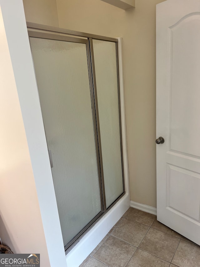 bathroom with tile patterned floors and a shower with shower door