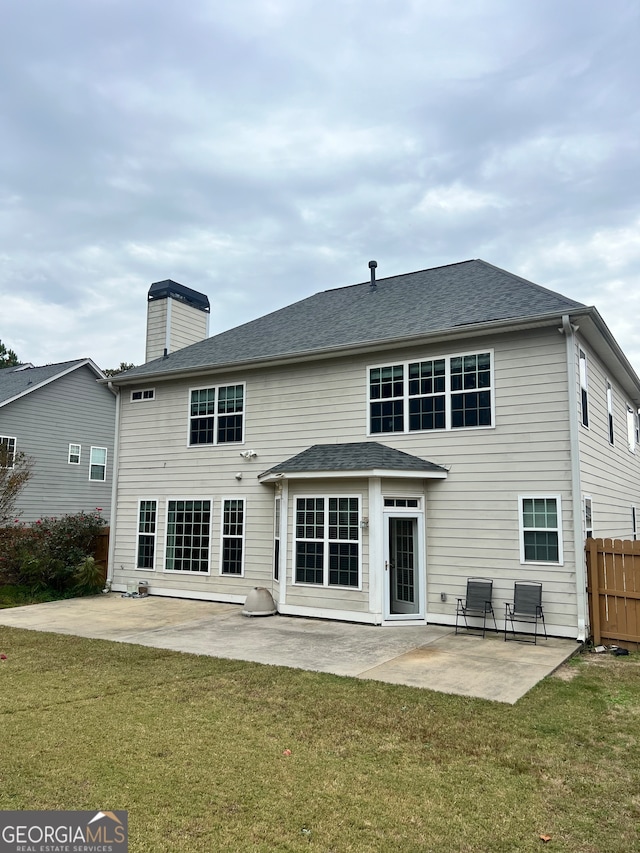 back of property with a patio area and a lawn