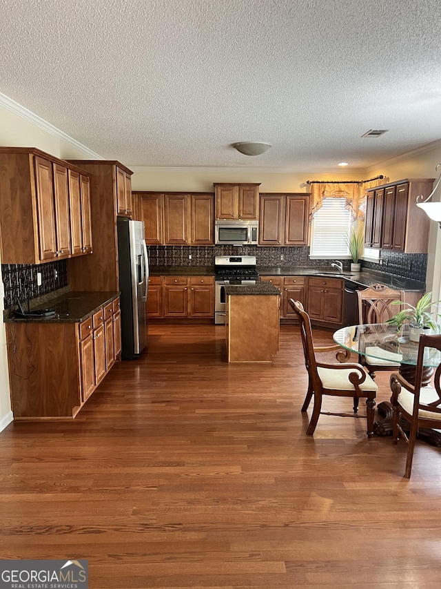 165 Summit Point Dr, Fayetteville, GA 30214 - kitchen with appliances with stainless steel finishes, a textured ceiling, a kitchen island, dark wood-style floors, and a sink
