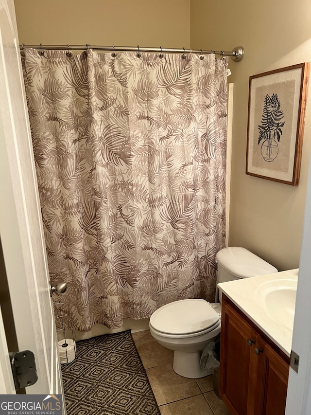 bathroom featuring vanity, a shower with shower curtain, toilet, and tile patterned floors